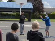 Union's Rory Rosenbach, left, and Mountain View's Adam Mathieson demonstrate how to navigate through a game that involves no contact and rock, paper, scissors for youngsters at Crestline Elementary School on Monday afternoon, April 27, 2020.