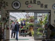 Vancouver resident Rich Packer, right in blue hat, joins fellow shoppers as they look to brighten up their homes with flowers and plants at Yard &#039;n Garden Land on Tuesday. The business has been experiencing a boost in sales in recent months due to shoppers turning to home garden projects during the pandemic.