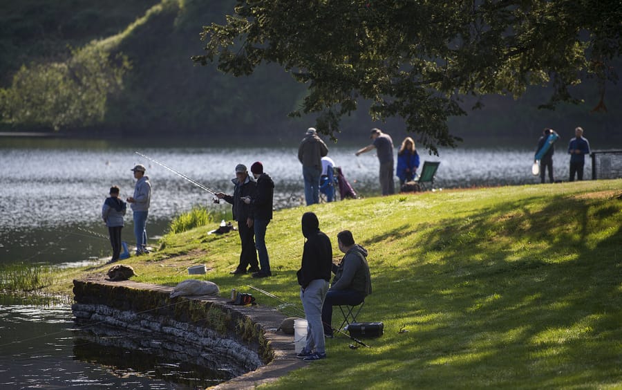 Fishing enthusiasts of all ages gather along the shoreline at Klineline Pond in Salmon Creek in May 2020.