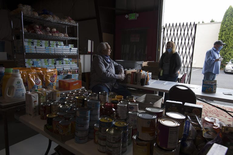 Volunteers Steve Marvin, from left, and Bethany Buslach join Randy Graves, director of development for The Giving Closet, as they wait to distribute food to residents in need Thursday morning, May 14, 2020. The Giving Closet, which normally operates a clothing closet for low-income households, is giving away boxes of food.