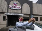 Sound technician Peter Wonderly wears a mask for safety as he snaps a selfie after putting the finishing touches on the front sign at the Magenta Theater in downtown Vancouver on Friday. Magenta Theater, which is dark during the COVID-19 pandemic, came up with the idea of renting out its Main Street marquee for community messages.