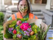 Stephanie Haynes, partnerships and programs manager at the Vancouver Farmers Market, puts together a box of local goods for pickup at the market.