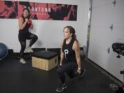 Coaches Barbara Laudadio, left, and Traci Cole of Burntown Fitness create a workout video for home users in their boss&#039;s garage.