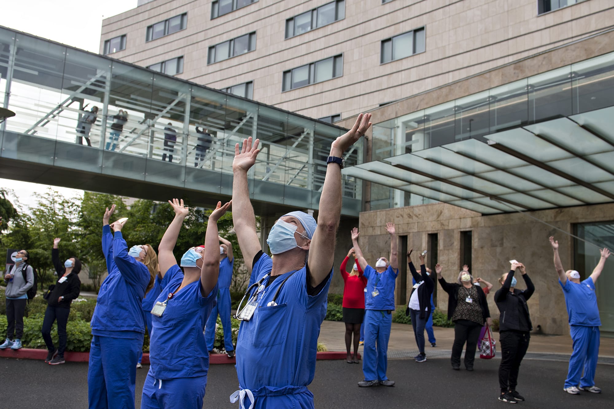 Dr. Pierre Provost, an anesthesiologist at Legacy Salmon Creek Medical Center, joins colleagues and hospital staff as they greet members of the Oregon Air National Guard as they fly two F-15 Eagles over the area on Friday morning, May 22, 2020. The flyovers, which are a combined effort from Oregon’s 173rd Fighter Wing and the 142nd Wing, were held to show gratitude to healthcare workers, first responders, and other essential staff who are working hard to keep local residents safe. The tribute, which traveled west to east over the facility, continued on to visit other hospitals in the region.