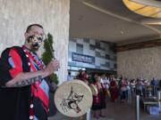 Jeramiah Wallace of the Cowlitz Drum Group, left, keeps the beat while celebrating the reopening of ilani Casino Resort with the crowd on Thursday morning, May 28, 2020.