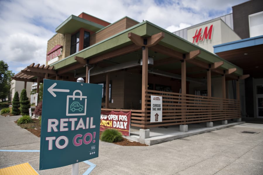 Signs direct shoppers where to pick up their purchases through the Retail To Go program at Vancouver Mall. The mall remains closed, but several retailers are providing curbside pick-up services.