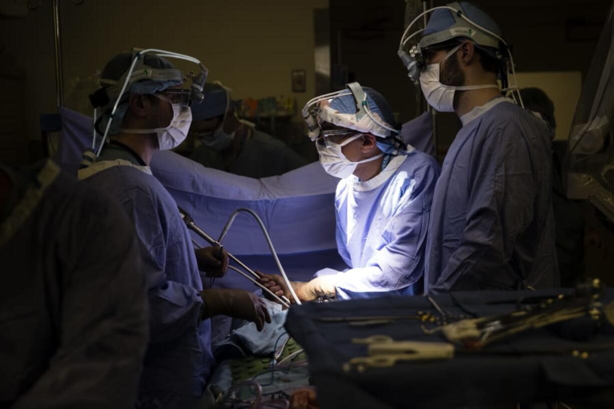 FILE - In this Tuesday, Jan. 23, 2018 file photo, a doctor, center, directs a special camera to look at a patient&#039;s tumor at a hospital in Philadelphia. According to research released on Wednesday, May 13, 2020, cancer deaths have dropped more in states that expanded Medicaid coverage under the Affordable Care Act than in states that did not.