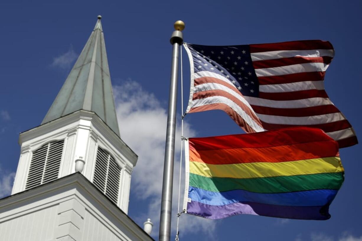 A gay pride rainbow flag flies along with the U.S. flag April 19, 2019, in front of the Asbury United Methodist Church in Prairie Village, Kan. Had there been no COVID-19 coronavirus pandemic, America&#039;s largest mainline Protestant denomination would be convening in May.