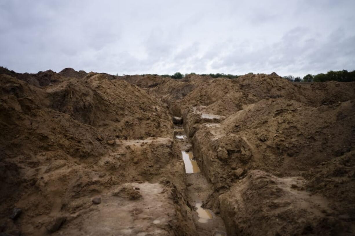 In this Wednesday, Oct. 2, 2019 photo, long-buried trench lines and military positions are excavated to search for fallen WWII soldiers near the village of Klessin, Germany. In eastern Germany, today&#039;s verdant pastures were killing fields 75 years ago as the Soviet Red Army pushed toward the Nazi capital in the final weeks of World War Two. Volunteers from across Europe comb across the area looking for the remains of the thousands of missing soldiers, working from old maps and aerial photos to identify the trenches, foxholes and strongpoints where they could be buried. They strive to give the dead a proper burial, and wherever possible identify the remains to provide closure for families.