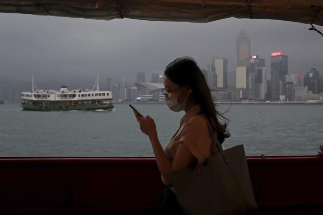 In this Thursday, May 28, 2020, photo, a woman uses a smartphone on a ferry in Hong Kong. Hong Kong has been living on borrowed time ever since the British made it a colony nearly 180 years ago, and all the more so after Beijing took control in 1997, granting it autonomous status. A national security law approved by China&#039;s legislature Thursday is a reminder that the city&#039;s special status is in the hands of Communist Party leaders who have spent decades building their own trade and financial centers to take Hong Kong&#039;s place.