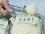 This May 4, 2020, image made from video shows a scoop of tear gas flavor ice cream, in Hong Kong. A Hong Kong ice cream shop has created this flavor using pepper, in memory of all the tear gas fired by the Hong Kong police in recent months. The flavor is a sign of support for the pro-democracy movement, which is seeking to regain its momentum during the coronavirus pandemic, the shop&#039;s owner said.