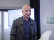 FILE - In this Thursday, Sept. 19, 2019 file photo, Amazon CEO Jeff Bezos walks off stage after holding a news conference at the National Press Club in Washington to announce the Climate Pledge, setting a goal to meet the Paris Agreement 10 years early. On Monday, Feb. 17, 2020, Bezos said that he plans to spend $10 billion of his own fortune to help fight climate change.