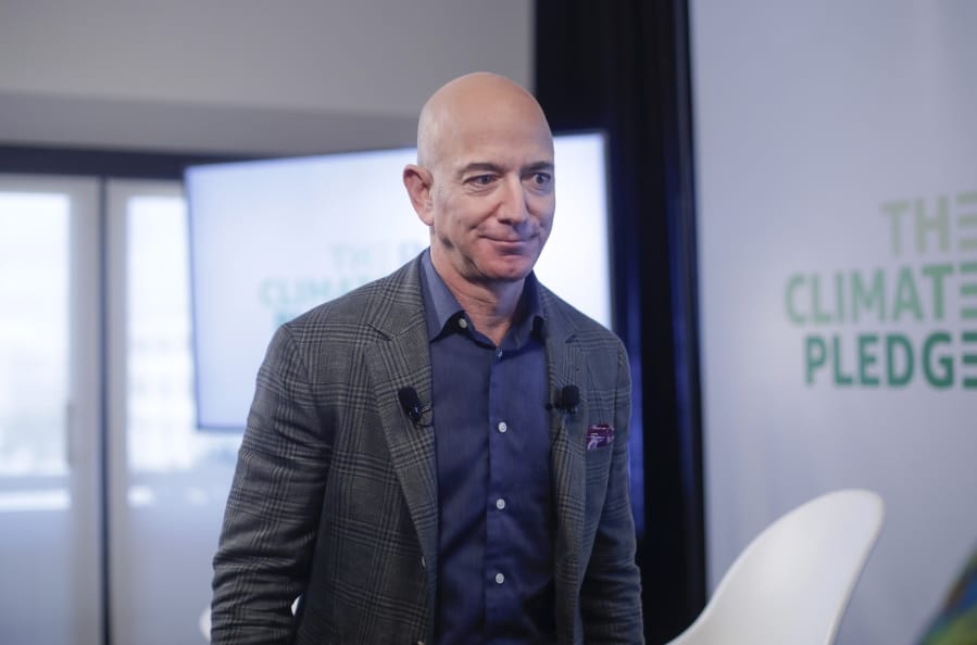 FILE - In this Thursday, Sept. 19, 2019 file photo, Amazon CEO Jeff Bezos walks off stage after holding a news conference at the National Press Club in Washington to announce the Climate Pledge, setting a goal to meet the Paris Agreement 10 years early. On Monday, Feb. 17, 2020, Bezos said that he plans to spend $10 billion of his own fortune to help fight climate change.