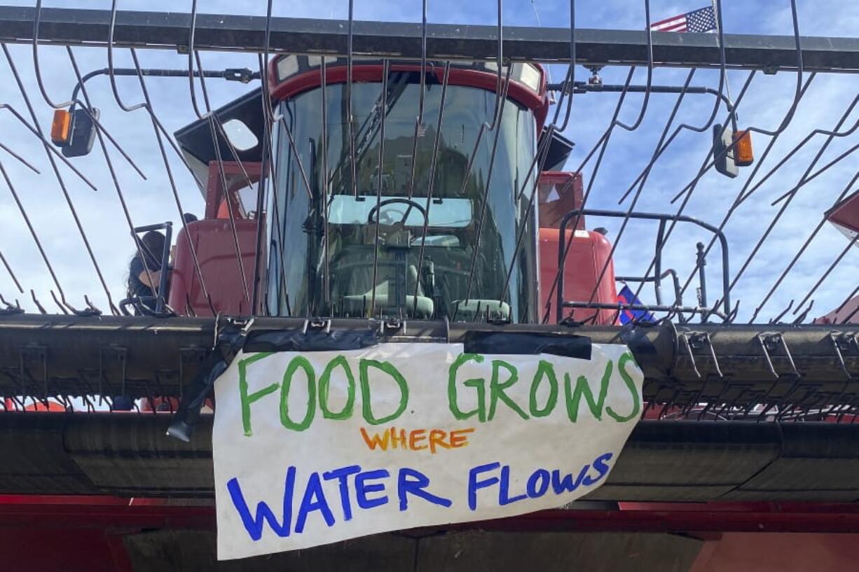 A sign reading &quot;Food grows where water flows&quot; is attached to farm equipment Friday near Merrill, Ore., as farmers upset about water issues planned a convoy.