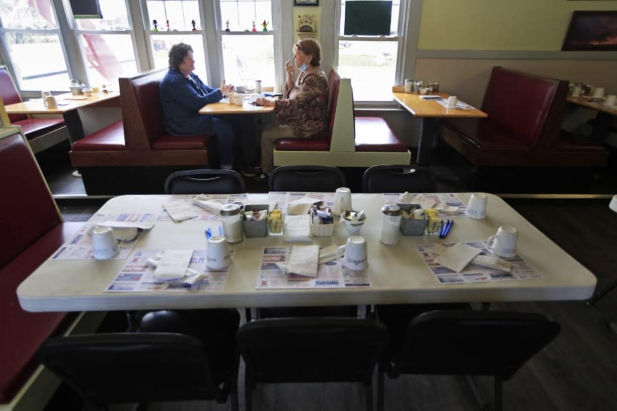 FILE - In this May 18, 2020 file photo, customers dine inside at the Hot Spot Diner in Wiscasset, Maine.  Governor Janet Mills is now allowing restaurants in 12 of the state&#039;s 16 counties to have dine-in customers. As of this week, 32 states have allowed dining rooms to open at least partially. And restaurant executives say customers are curious and eager to eat out.(AP Photo/Robert F.