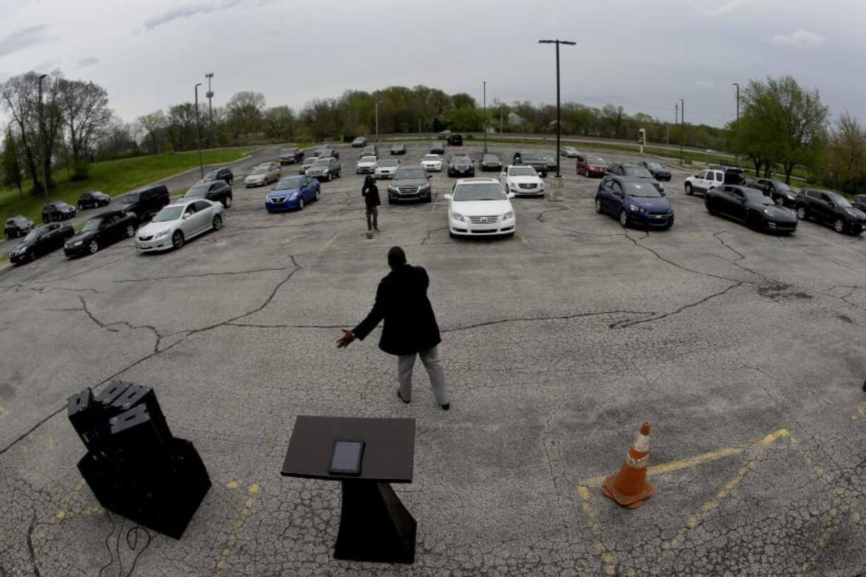 FILE - In this April 12, 2020 file photo, Pastor W.R. Starr II preaches during a drive-in Easter Sunday service while churchgoers listen from their cars in the parking lot at Faith City Christian Center in Kansas City, Kan. As the nation&#039;s houses of worship weigh how and when to resume in-person gatherings while coronavirus stay-at-home orders ease in some areas, a new poll conducted April 30 - May 4, 2020 points to a partisan divide over whether restricting those services violates religious freedom.