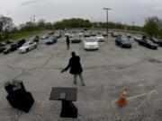 FILE - In this April 12, 2020 file photo, Pastor W.R. Starr II preaches during a drive-in Easter Sunday service while churchgoers listen from their cars in the parking lot at Faith City Christian Center in Kansas City, Kan. As the nation&#039;s houses of worship weigh how and when to resume in-person gatherings while coronavirus stay-at-home orders ease in some areas, a new poll conducted April 30 - May 4, 2020 points to a partisan divide over whether restricting those services violates religious freedom.