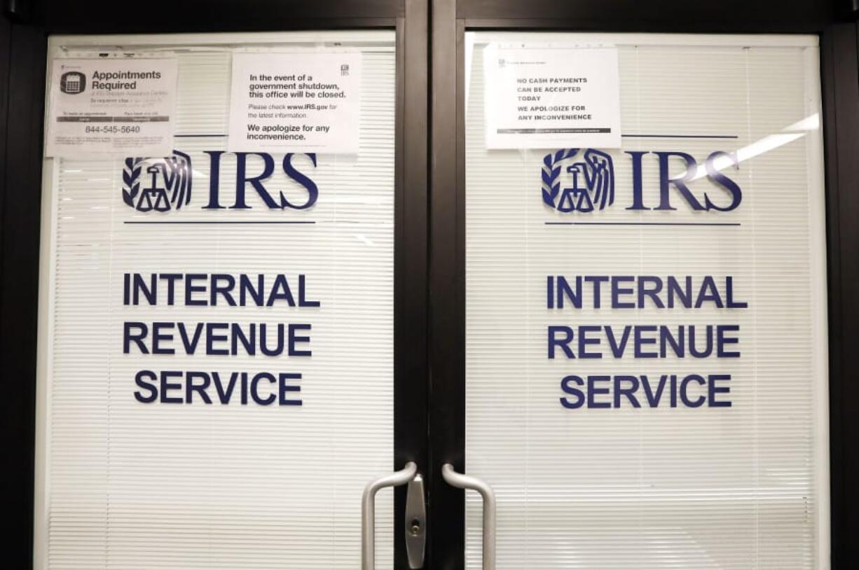 FILE - In this Jan. 16, 2019, file photo, doors at the Internal Revenue Service (IRS) in the Henry M. Jackson Federal Building are locked and covered with blinds as a sign posted advises that the office will be closed during the partial government shutdown in Seattle.