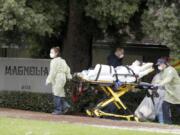 A patient at Magnolia Rehabilitation and Nursing Center in Riverside, Calif., is evacuated April 8 to a waiting ambulance. For nearly two months, many nursing homes nationwide have been on virtual lockdown. Families of residents are not allowed inside, vendors have to drop deliveries outside and the only people coming in and out are health care workers and assistants.