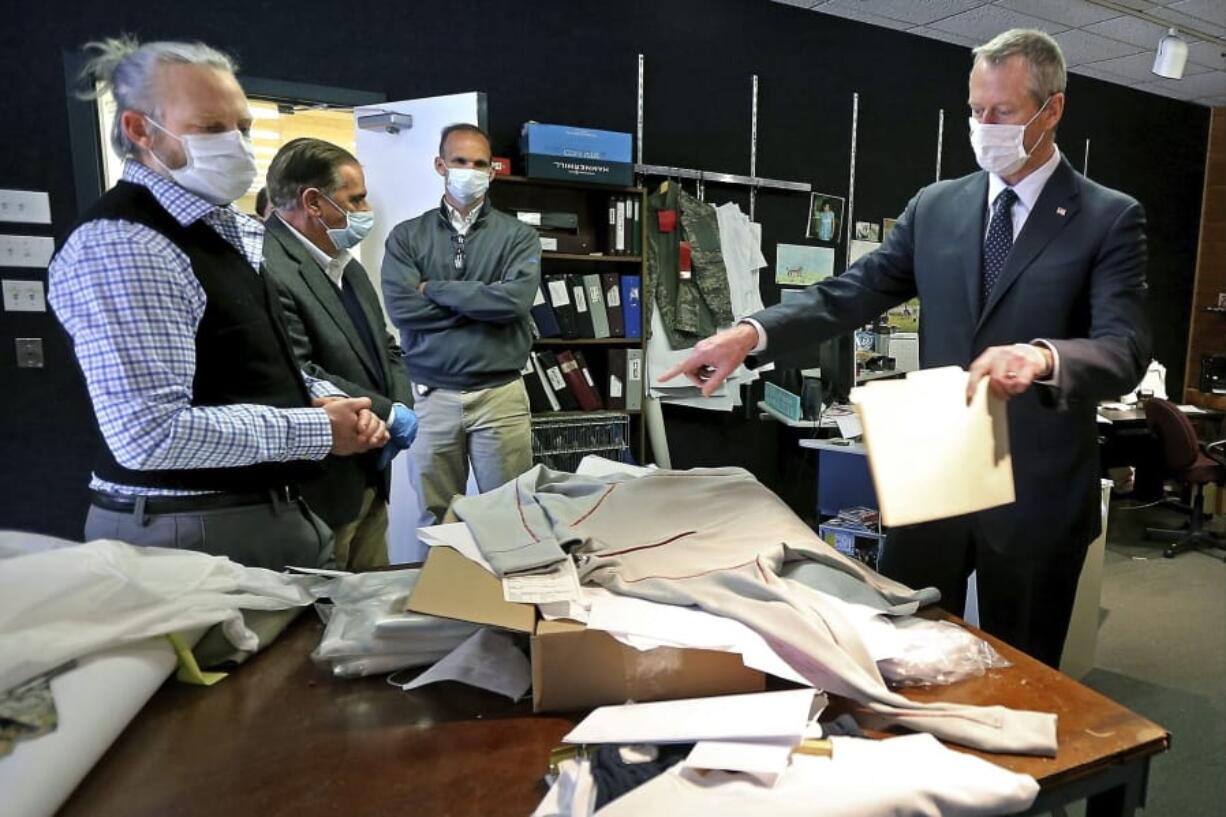 In this Tuesday, May 5, 2020, photo, Gov. Charlie Baker, right, wearing a protective mask for the coronavirus pandemic, views products with Charlie Merrow, left, CEO of Merrow Manufacturing Merrow while touring the plant in Fall River, Mass. Merrow&#039;s company is adapting its textile operations to produce personal protective equipment. After being forced to buy protective medical gear in a chaotic and expensive marketplace, more governors are pledging to have it manufactured in their own states.