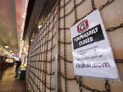 A sign explains the closure of a shop in the Pike Place Market in Seattle.