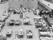 FILE - In this 1918 file photo made available by the Library of Congress, volunteer nurses from the American Red Cross tend to influenza patients in the Oakland Municipal Auditorium, used as a temporary hospital. Science has ticked off some major accomplishments over the last century. The world learned about viruses, cured various diseases, made effective vaccines, developed instant communications and created elaborate public-health networks. Yet in many ways, 2020 is looking like 1918, the year the great influenza pandemic raged. (Edward A.