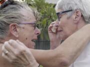 Christine Archer, right, and her sister Gail Baker cry as they are reunited in Bowraville, Australia Wednesday, May 20, 2020. Australia had rejected Archer&#039;s request for permission to fly from New Zealand four times before her story attracted media attention. Her only sister Baker was diagnosed with incurable ovarian cancer in late March after both countries stopped international travel. Baker has perhaps weeks to live. Archer was eventually allowed to fly to Sydney and spent only a week in hotel quarantine before testing negative for the coronavirus.