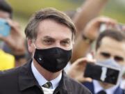 Brazil&#039;s President Jair Bolsonaro stands amid supporters taking pictures with cellphones as he leaves his residence of Alvorada palace in Brasilia, Brazil on Monday.