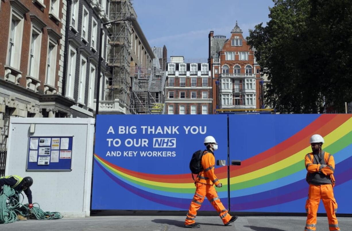 A construction worker passes a sign thanking the NHS in London, as the country in is lockdown to prevent the spread of coronavirus, Thursday, May 7, 2020. The coronavirus has had a dramatic impact on the construction industry. The Bank of England has warned that the British economy could be nearly a third smaller by the end of the first half of this year as a result of the coronavirus pandemic, but also notes the economy could revive quickly.