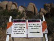 Signs advise visitors to social distance at Joshua Tree National Park in California, Tuesday, May 19, 2020. The park reopened this week after a lengthy closure to help slow the spread of the new coronavirus. (AP Photo/Jae C.