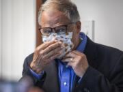 Washington Gov. Jay Inslee puts on his face mask after speaking to the media, Wednesday, May 20, 2020, in Tumwater, Wash., about the state&#039;s effort at contact tracing amid the coronavirus pandemic.