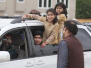 A family looks out from their vehicle during an Eid al-Fitr drive through celebration outside a closed mosque in Plano, Texas, Sunday, May 24, 2020. Many Muslims in America are navigating balancing religious and social rituals with concerns over the virus as they look for ways to capture the Eid spirit this weekend.