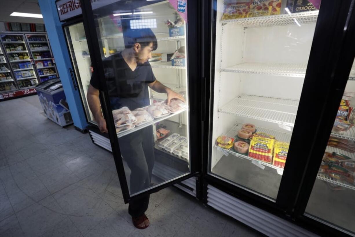 Hardik Kalra stocks meat in a cooler at a local super market, Friday, May 29, 2020, in Des Moines, Iowa. As if trips to the grocery store weren&#039;t nerve-racking enough, shoppers lately have seen the costs of meat, eggs and even potatoes soar as the coronavirus has disrupted processing plants and distribution networks.