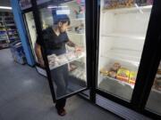 Hardik Kalra stocks meat in a cooler at a local super market, Friday, May 29, 2020, in Des Moines, Iowa. As if trips to the grocery store weren&#039;t nerve-racking enough, shoppers lately have seen the costs of meat, eggs and even potatoes soar as the coronavirus has disrupted processing plants and distribution networks.