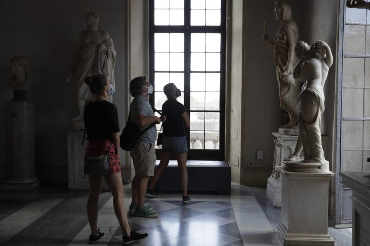 Visitors wearing a face masks to prevent the spread of COVID-19 admire statues in the Rome Capitoline Museums, including the second century A.D. Roman marble statue &quot;Cupid and Psyche&quot;, at right, Tuesday, May 19, 2020. In Italy, museums were allowed to reopen this week for the first time since early March, but few were able to receive visitors immediately as management continued working to implement social distancing and hygiene measures, as well as reservation systems to stagger visits to museums in the onetime epicenter of the European pandemic.