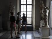 Visitors wearing a face masks to prevent the spread of COVID-19 admire statues in the Rome Capitoline Museums, including the second century A.D. Roman marble statue &quot;Cupid and Psyche&quot;, at right, Tuesday, May 19, 2020. In Italy, museums were allowed to reopen this week for the first time since early March, but few were able to receive visitors immediately as management continued working to implement social distancing and hygiene measures, as well as reservation systems to stagger visits to museums in the onetime epicenter of the European pandemic.