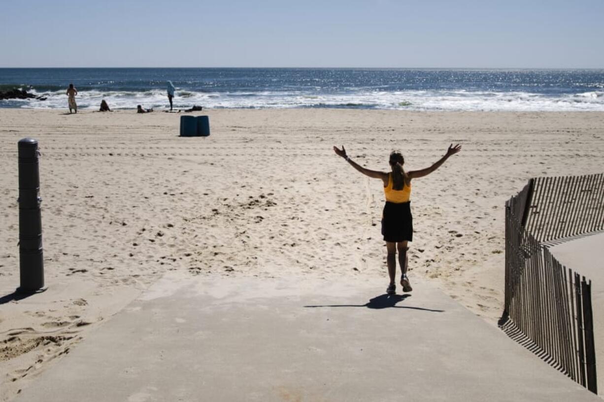 A woman walks on the beach during the coronavirus pandemic in Belmar, N.J., Saturday, May 2, 2020.