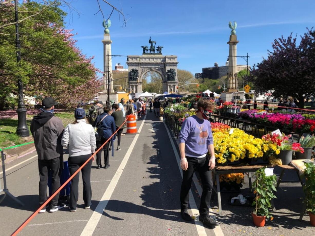 Shoppers wait on one of several lines to make purchases at the farmer&#039;s market at Grand Army Plaza in Brooklyn on Saturday, May 2, 2020. As warmer temperatures tempted New Yorkers to come out of quarantine due to coronavirus, police dispatched 1,000 officers this weekend to enforce social distancing and a ban on congregating in public spaces.