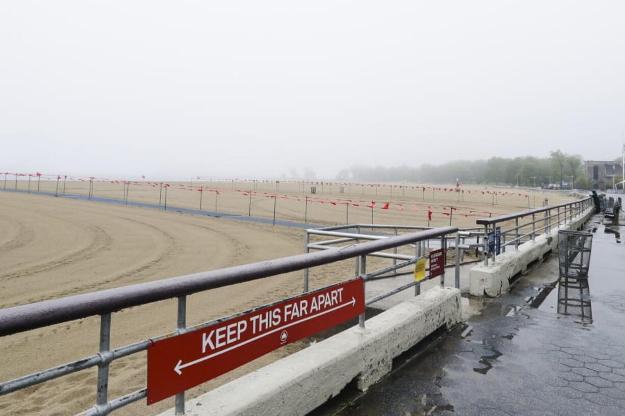 New York City Parks officials work at an empty Orchard Beach Saturday, May 23, 2020, in the Bronx borough of New York.  Gov. Andrew Cuomo has given New Yorkers an unexpected reprieve from cabin fever by easing the state&#039;s ban on gatherings due to coronavirus concerns, in time for the Memorial Day weekend.   New York City beaches are open this weekend. But no swimming is allowed, and masks must be worn.