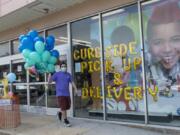 A Party City employee delivers balloons to a customer curbside, Wednesday, May 27, 2020, in Oceanside, N.Y. Long Island has become the latest region of New York to begin easing restrictions put in place to curb the spread of the coronavirus as it enters the first phase of the state&#039;s four-step reopening process.