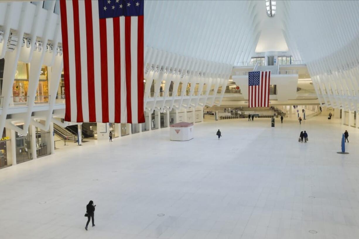 Pedestrians walk through the nearly empty Oculus during the coronavirus pandemic Saturday, May 9, 2020, in New York.