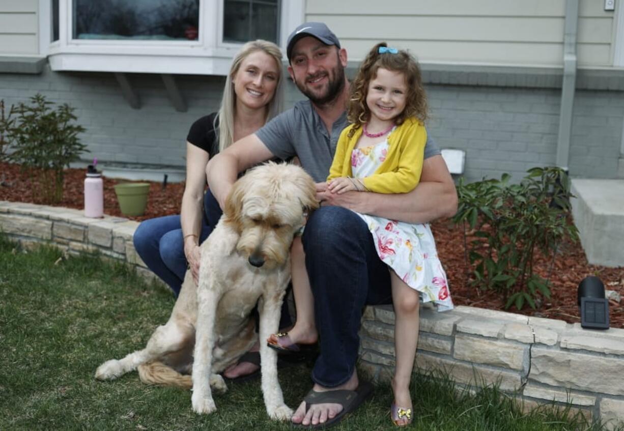 Eli Oderberg, center, sits with Katie Evers, left, their 4-year-old daughter, Everlee, and the couple&#039;s goldendoodle outside their home in southeast Denver on Thursday, April 30, 2020. Oderberg, like 30 million people around the United States who have filed for unemployment benefits after losing their jobs during the coronavirus pandemic, is facing the specter of paying the monthly rent with the flip of the calendar.