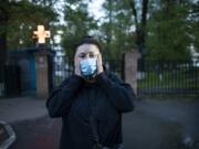 In this photo taken on Monday, May 18, 2020, Dr. Irina Vaskyanina adjusts a face mask to protect against coronavirus during her interview with the Associated Press in front of a hospital in Reutov, just outside Moscow, Russia. Vaskyanina headed a department handling blood transfusions at a hospital in Reutov, outside Moscow, and spent weeks fighting for better working conditions after 40 of her colleagues got infected with the virus and dozens quit.