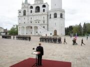 Russian President Vladimir Putin, back to a camera, watches the honour guard of the Presidential Regiment march on Cathedral Square in the Kremlin marking the 75th anniversary of the Nazi defeat in World War II in Moscow, Russia, Saturday, May 9, 2020.