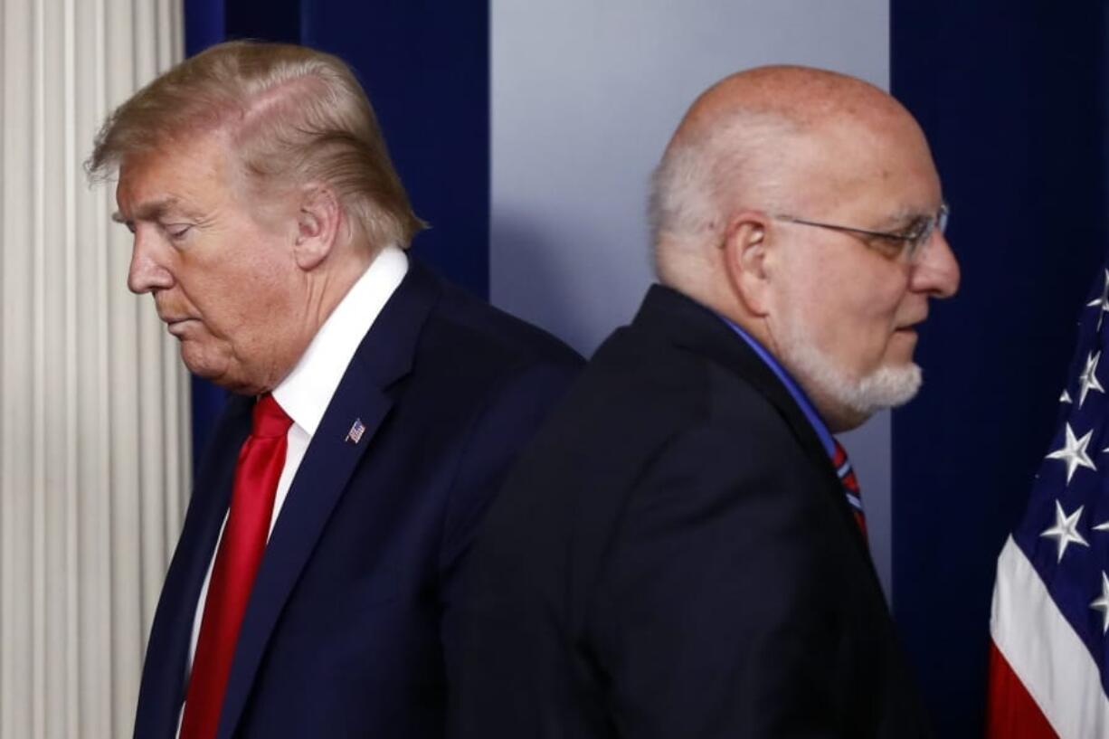 FILE - In this April 22, 2020, file photo President Donald Trump passes Dr. Robert Redfield, director of the Centers for Disease Control and Prevention, during a briefing about the coronavirus in the James Brady Press Briefing Room of the White House in Washington.