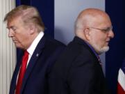 FILE - In this April 22, 2020, file photo President Donald Trump passes Dr. Robert Redfield, director of the Centers for Disease Control and Prevention, during a briefing about the coronavirus in the James Brady Press Briefing Room of the White House in Washington.