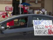 FILE - In this April 13, 2020, file photo, a car passes nurses protesting the lack of N95 respirators and other Personal Protective Equipment outside the UCLA Medical Center, Santa Monica amid the coronavirus pandemic in Santa Monica, Calif. An Associated Press review of more than 20 states found that before the coronavirus outbreak many had at least a modest supply of N95 masks, gowns, gloves and other medical equipment. But those were often well past their expiration dates -- left over from the H1N1 influenza outbreak a decade ago.