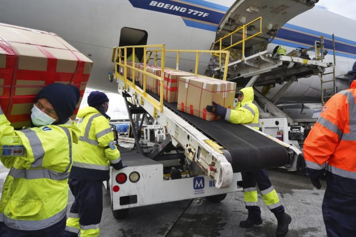 FILE - In this April 10, 2020, file photo, wearing protective masks ground crew at the Los Angeles International airport unload supplies of medical personal protective equipment, PPE, from a China Southern Cargo plane upon it&#039;s arrival. States are spending billions of dollars stocking up on medical supplies like masks and breathing machines during the coronavirus pandemic. An Associated Press survey of all 50 states found a hodgepodge of public information about the purchase of masks, gloves, gowns and other hard-to-get equipment for medical and emergency workers.