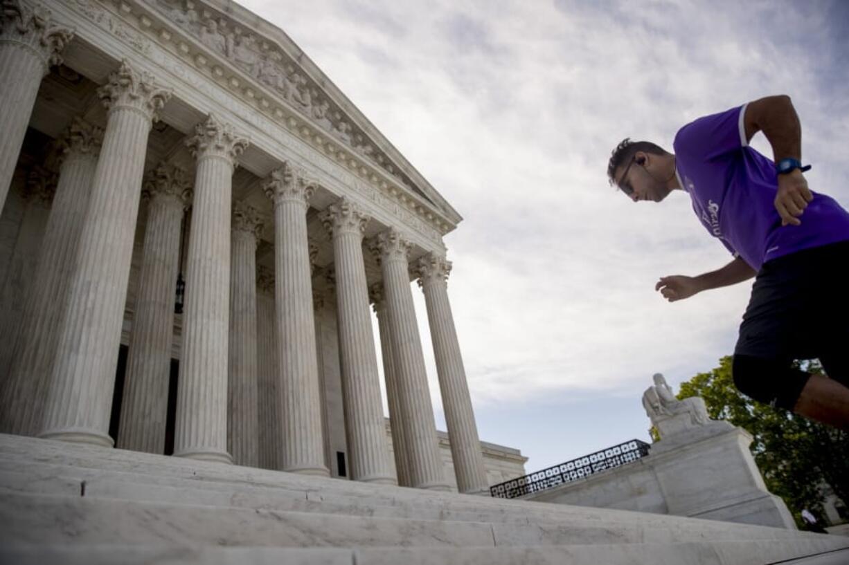 A man exercises on the steps of the Supreme Court where the justices will hold arguments by telephone for the first time ever, Monday, May 4, 2020, in Washington.