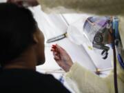 FILE - In this April 20, 2020, photo, a test is performed on a patient in a COVID-19 triage tent at St. Joseph&#039;s Hospital in Yonkers, N.Y. An Associated Press analysis finds that most states are not meeting the minimum levels of testing suggested by the federal government and recommended by public health researchers even as many of them begin to reopen their shattered economies.